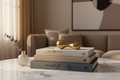 Styled stack of three design coffee-table books on a marble table